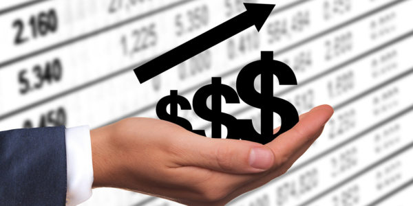 A hand holds three dollar signs with an up arrow above it.