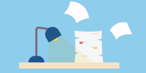 A desk with a blue lamp and a stack of papers, with some flying away