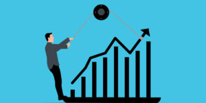 Man in suit leveraging pulley on bar chart to move arrows upward