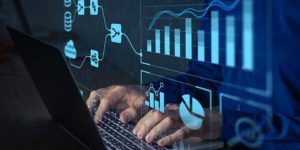 Man sitting at keyboard with numerous graphs and charts floating around him.