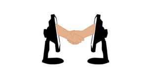 Two arms coming out of two computers shaking hands.