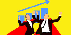 Two people in red capes standing in front of a blue graph showing sales growth