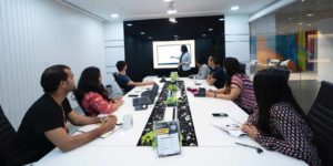A group of people sitting around watching a presentation.
