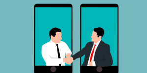 Two people inside iPhones reaching outside of the iPhones and shaking hands.