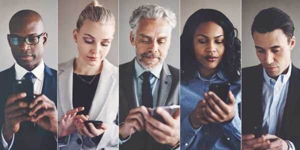 A group of people in dress clothes texting on their smartphones.