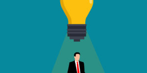 A person in a suit and tie with a giant lightbulb above them