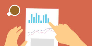 A person looking at a piece of paper containing graphs and charts.
