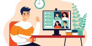 A man sits in front of a computer and waves to his co-workers during a video meeting
