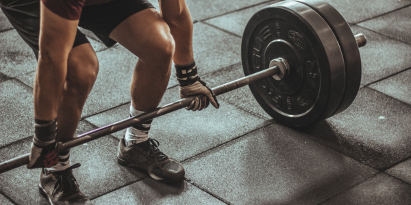 Lifting_at_Gym A person deadlifts a weighted barbell at a gym