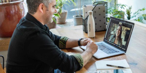 A man meets with a woman virtually through a video meeting.