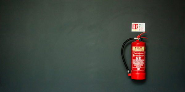 Fire_Extinguisher A fire extinguisher on a dark gray wall.