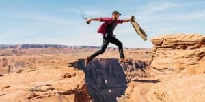 Man jumping over a gap in the rock.