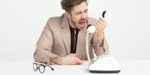 Man holding phone screaming.