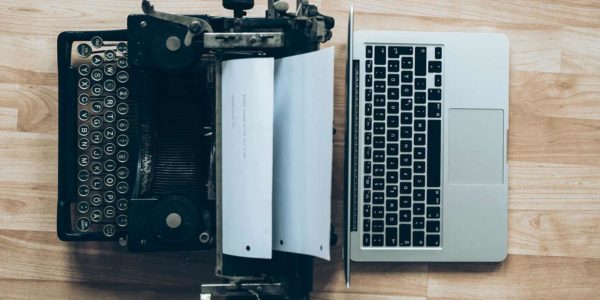 Gray typewriter and gray macbook.