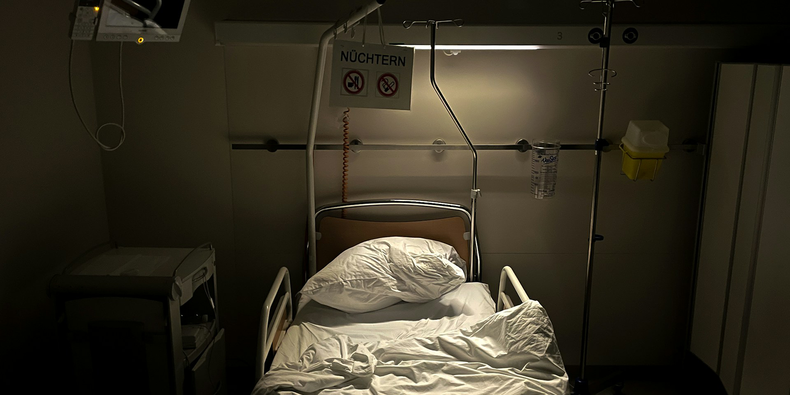 A dark room with a hospital bed.