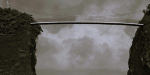 A bridge over a body of water under a cloudy sky.