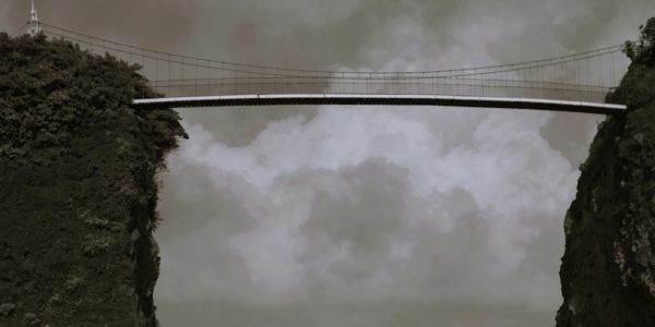 A bridge over a body of water under a cloudy sky.