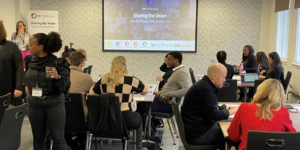 Group of professionals in a meeting discussing strategy with a senior woman leading the conversation