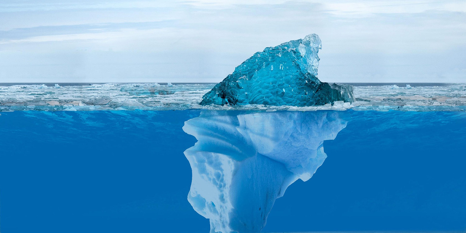 Iceberg floating in the ocean with a small visible tip above water and a massive submerged section beneath symbolizing unseen depth